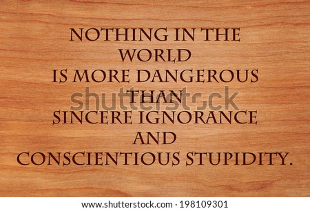 Nothing in the world is more dangerous than sincere ignorance and conscientious stupidity - quote on wooden red oak background