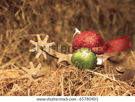 Cowboy Christmas - Christmas ornaments with a set of old rusty spurs on hay in sepia tone