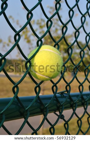 Tennis ball hit by power shot and stuck in fence