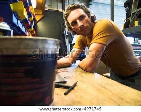 dirty male model working in work shop.. (mood lighting for effect)