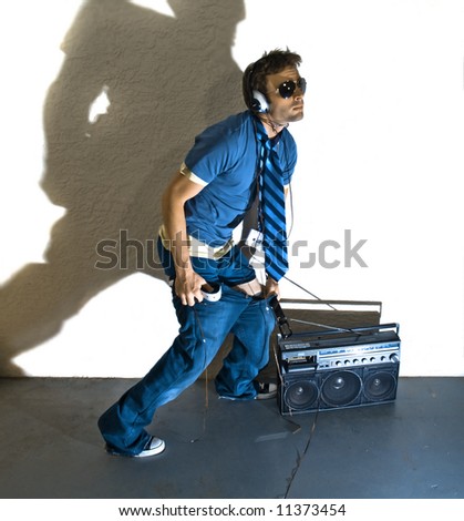 Male model with radio pulling up his pants. Grungy room and Fun lighting, with shadow