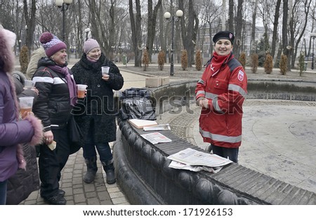 KIEV UKRAINE-JANUARY 17 , 2014: Pretty girl worker of Malteser International,humanitarian aid organization  communicates with people at time if dispensing food. EuroMaydan.