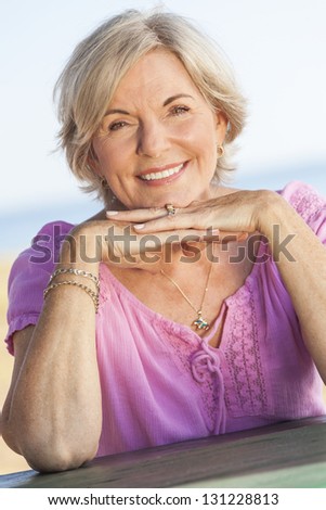 Outdoor portrait of an attractive elegant classy senior woman happy & smiling