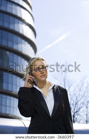 A beautiful young female executive using her mobile phone in a hi-tech urban setting