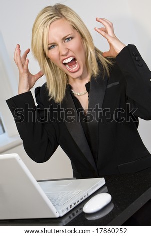 A beautiful young female executive expressing frustration at her laptop computer