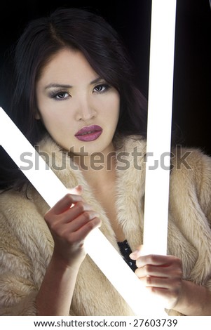 A stunningly beautiful young Japanese woman holding glowing fluorescent tubes in a nightclub setting