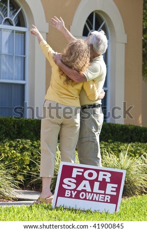 A senior retired man and woman looking at a house for sale with the sign in the foreground