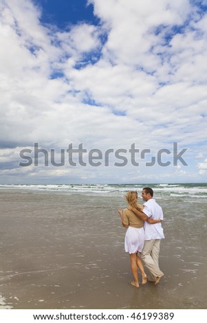 A young man and woman couple having romantic walk on a beach