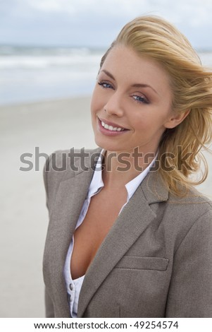 A beautiful young blond woman at the beach illuminated by natural light with her hair blowing in the wind