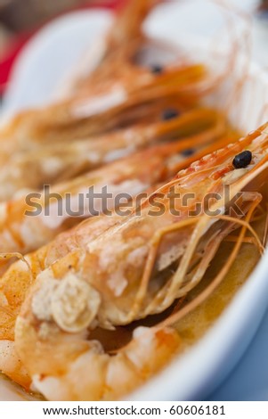 A dish of giant prawns or shrimps cooked in garlic butter, shot on location in a French seafood restaurant in Normandy, France, Europe