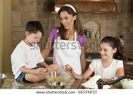 An smiling mother, daughter and son family cooking and baking chocolate chip cookies in a kitchen at home