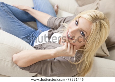 Overhead photograph of beautiful young woman at home sitting on sofa or settee relaxing and smiling