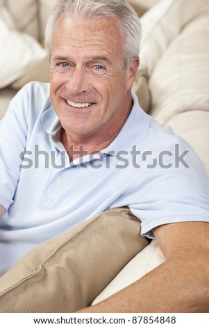 Happy and healthy senior man sitting on a sofa at home smiling and happy
