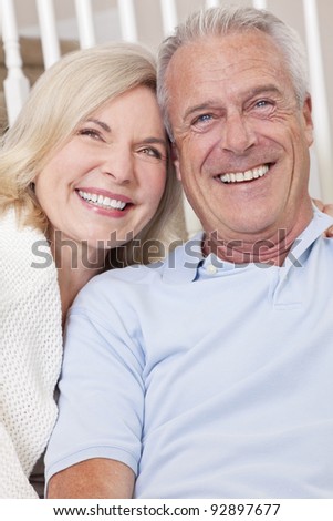 Happy senior man and woman couple sitting together at home smiling and happy