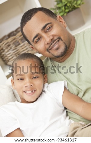 A happy African American man and boy, father and son, family sitting together at home