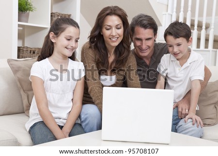 Happy family, parents, son and daughter, having fun using laptop computer together at home on a sofa.