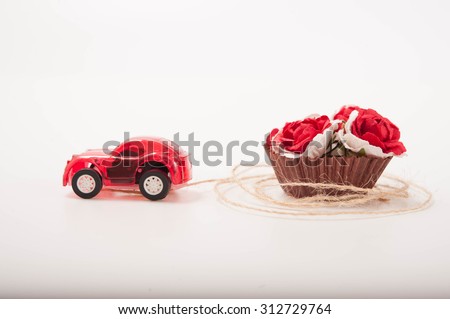 a red toy car is carrying some roses