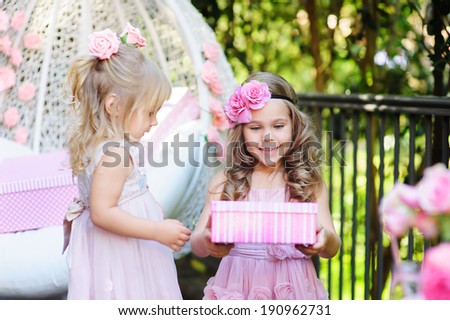 little child give a birthday gift box to her friend