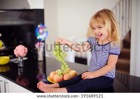 happy little kid eat fruit indoor