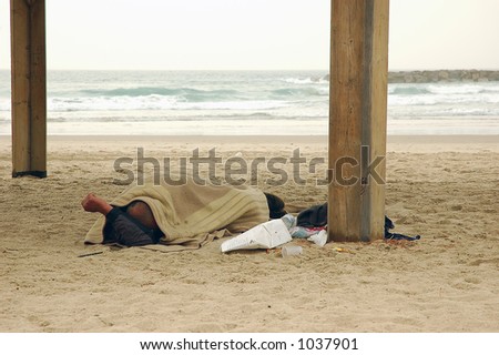 Homeless person sleeping on winter beach