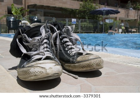 Pair of old shoes on edge of a pool