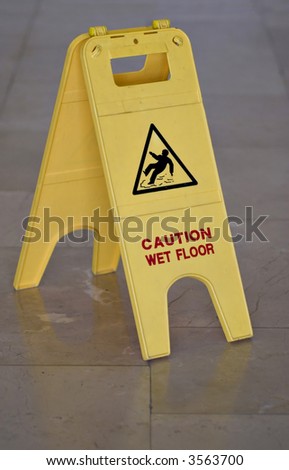 Yellow wet floor sign on marble floor