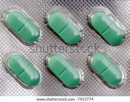 Closeup on pack of green pills