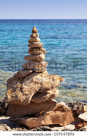 Zen stones stack on the shore with the sea as background
