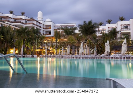 LANZAROTE, SPAIN - JUNE 25, 2014: Princess Yaiza hotel view at dusk, with no people and the swimming pool in the foreground in Lanzarote, Canary Islands, Spain on Jun 25, 2014