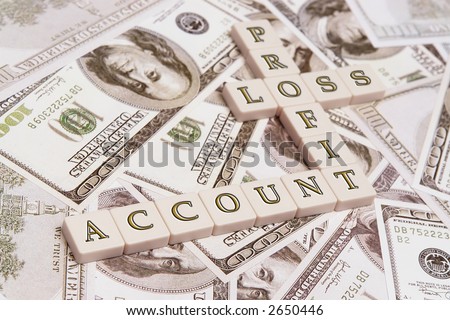 Letter cubes spelling account, profit, loss - placed over US one hundred dollar bills