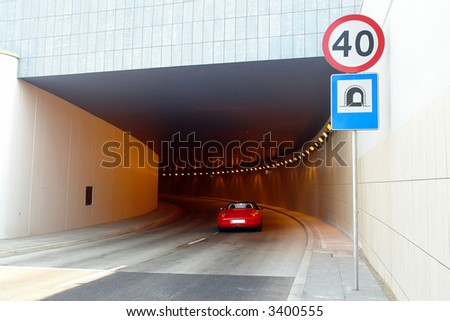 Red sports car entering tunnel
