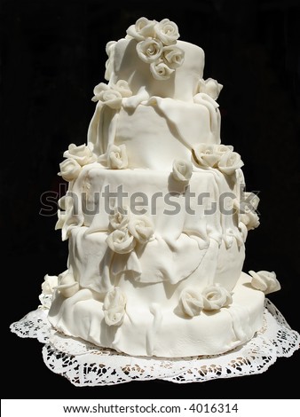 White iced wedding cake isolated on black background