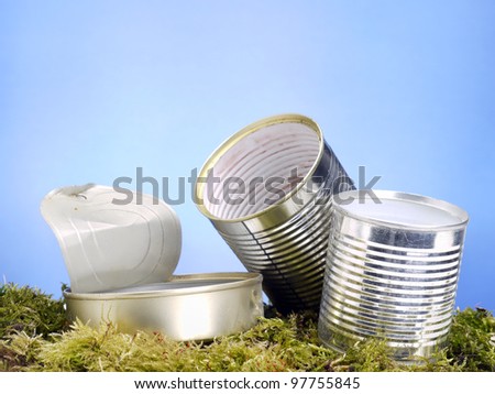 Empty food cans in the grass over blue sky