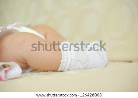 baby\'s feet in white socks with lace