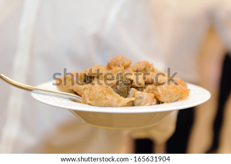 waiter holding plate with cabbage rolls