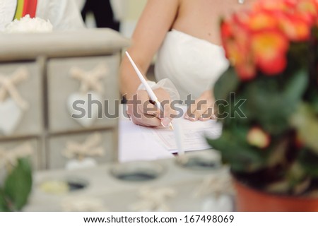 bride signing marriage certificate with white pen