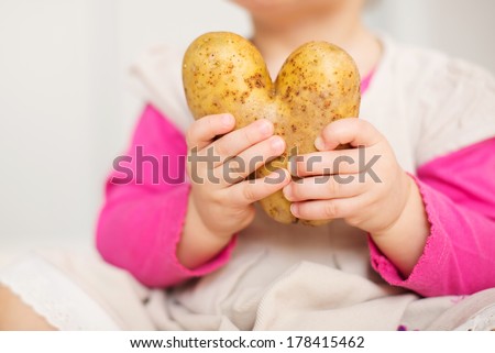 potato heart in hands of little girl