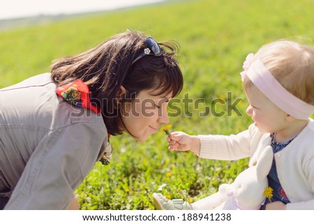 daughter giving dandelion her mother to smell
