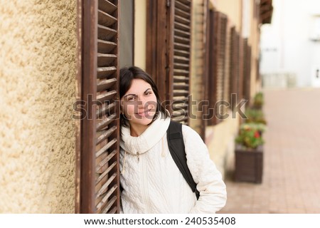 smiling woman with black straps of backpack