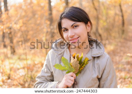 portrait of smiling woman with dry leaves bouquet