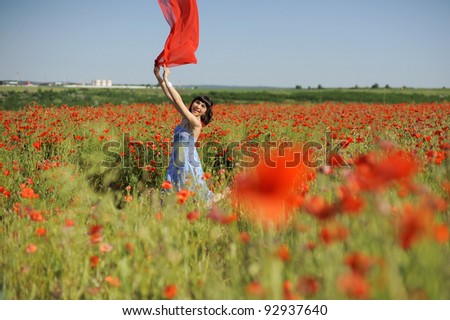 Attractive young woman having fun in a poppy field