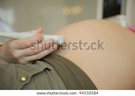 Pregnant woman checked by doctor. Focus on hand