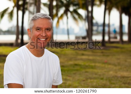 Handsome middle age man in casual clothing enjoying a park setting.