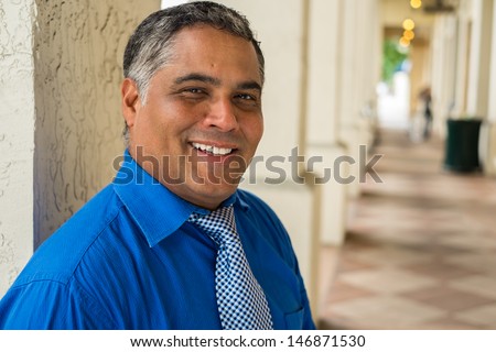Handsome middle age Hispanic man in an urban setting.