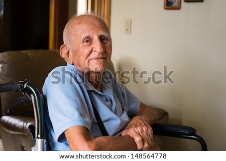 Elderly handicapped eighty plus year old man in a wheel chair in a home setting.