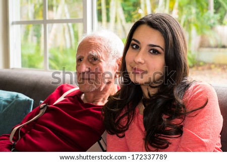 Elderly eighty plus year old man with granddaughter in a home setting.