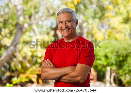 Handsome middle age man outdoor portrait with a green background.