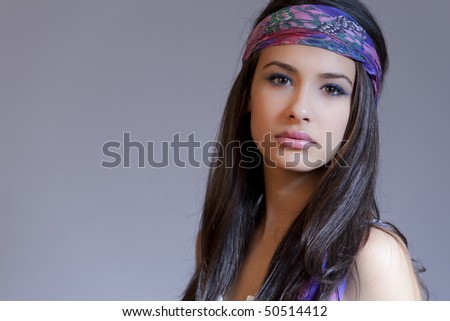 Beautiful young woman of multiple ethnicity in a glamour/fashion pose wearing a blue bandanna in a retro 1960s hippie chick pose.