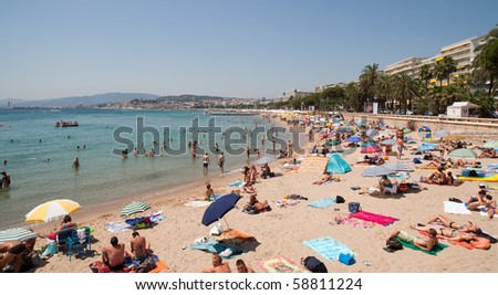 CANNES, FRANCE - JULY 14: Beach goers enjoying the sunshine and turquoise water of the Mediterranean Sea in celebration of Bastille Day in Cannes on July 14, 2010 in Cannes, France.