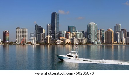 Panoramic Skyline view of Miami and Biscayne Bay from the Key Biscayne Bridge with fishing yacht cruising by.